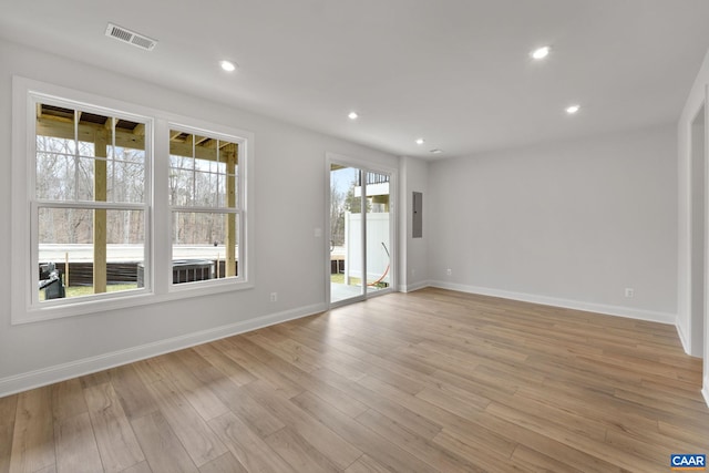 unfurnished room featuring light hardwood / wood-style flooring and electric panel