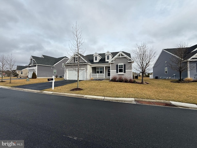 view of front facade featuring a garage, aphalt driveway, and a front yard