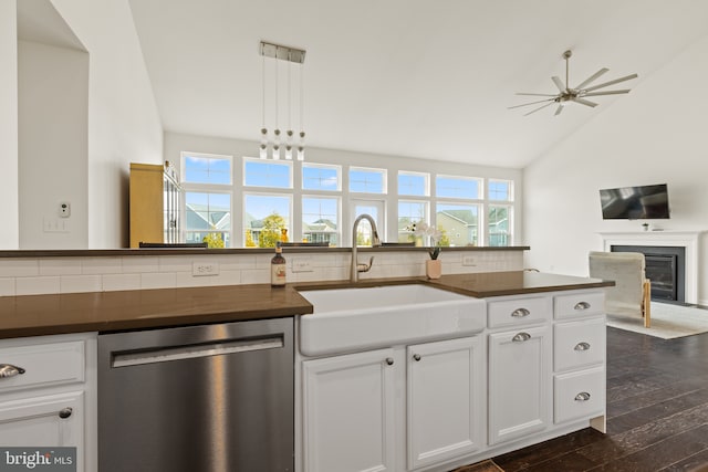 kitchen with a glass covered fireplace, dark wood-style floors, backsplash, stainless steel dishwasher, and a sink