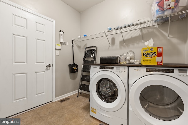 washroom featuring laundry area, visible vents, baseboards, and separate washer and dryer