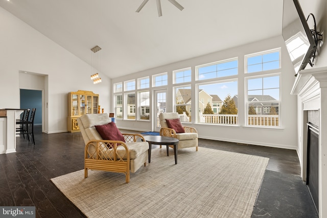 sitting room featuring high vaulted ceiling, dark wood-type flooring, a fireplace, and baseboards