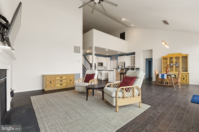 living area featuring dark wood-type flooring, ceiling fan, and high vaulted ceiling