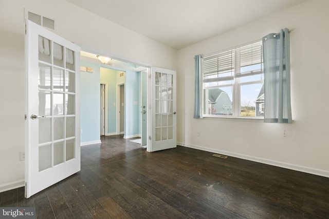 spare room with dark wood-type flooring, french doors, visible vents, and baseboards