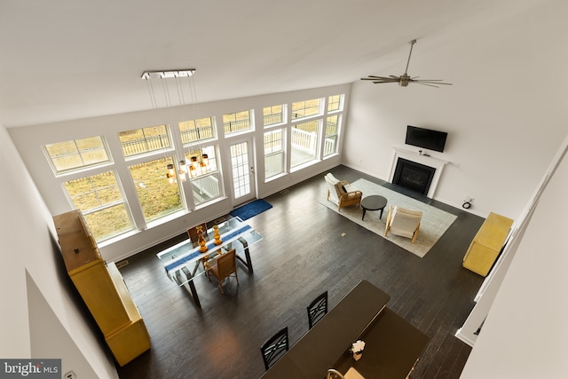 living room with a fireplace with flush hearth, baseboards, ceiling fan, and wood finished floors