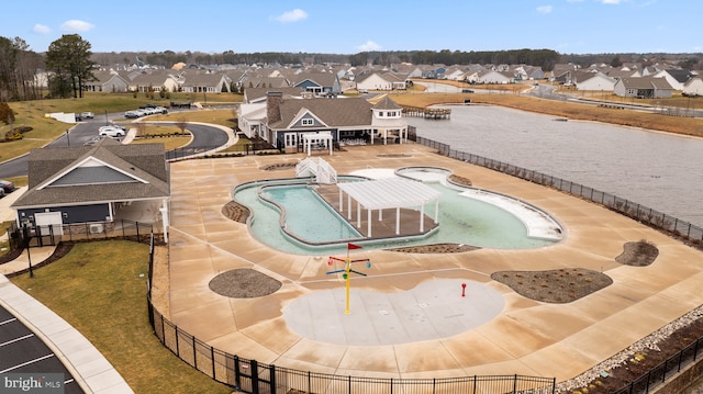 pool featuring a patio, a residential view, fence, a yard, and a water play area