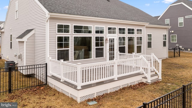 rear view of house featuring a shingled roof, cooling unit, a fenced backyard, and a wooden deck