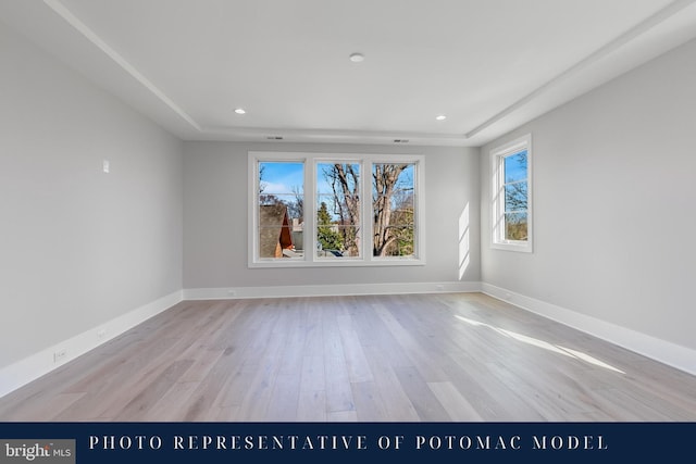 empty room with baseboards, light wood finished floors, and recessed lighting
