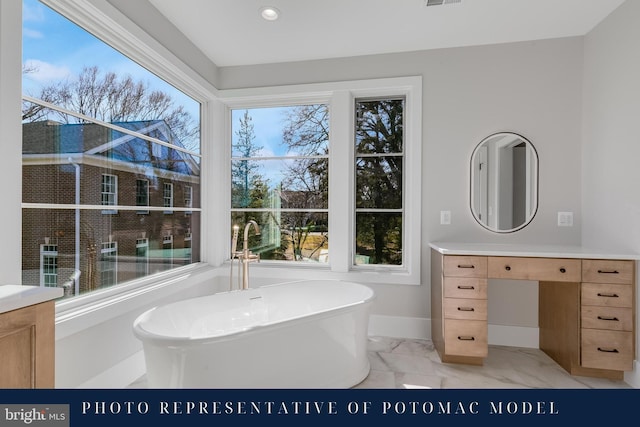 full bathroom featuring visible vents, baseboards, marble finish floor, vanity, and a freestanding bath