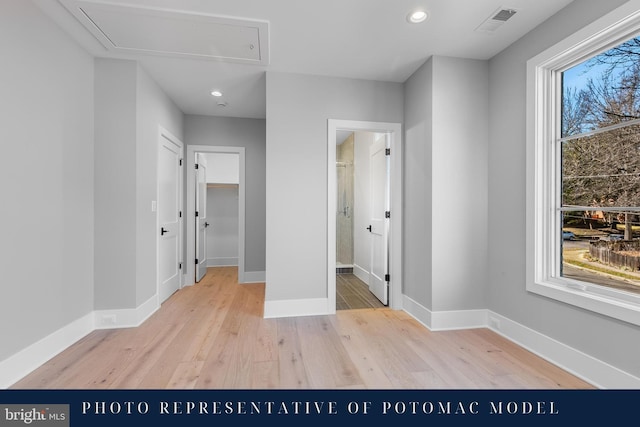unfurnished bedroom with attic access, light wood-style flooring, baseboards, visible vents, and recessed lighting