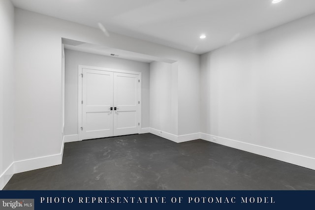 unfurnished room featuring concrete floors, baseboards, and recessed lighting