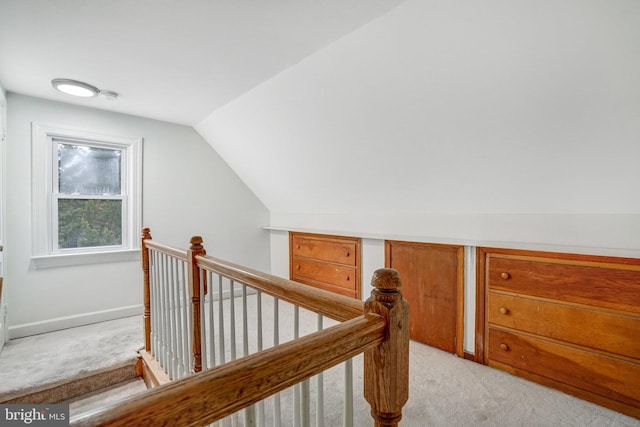 hallway featuring light carpet and lofted ceiling