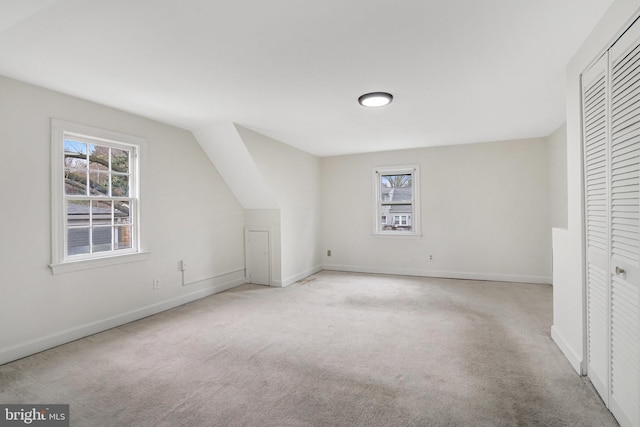 additional living space with light colored carpet and a healthy amount of sunlight