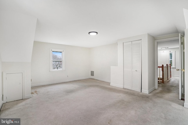 unfurnished bedroom featuring light colored carpet and a closet