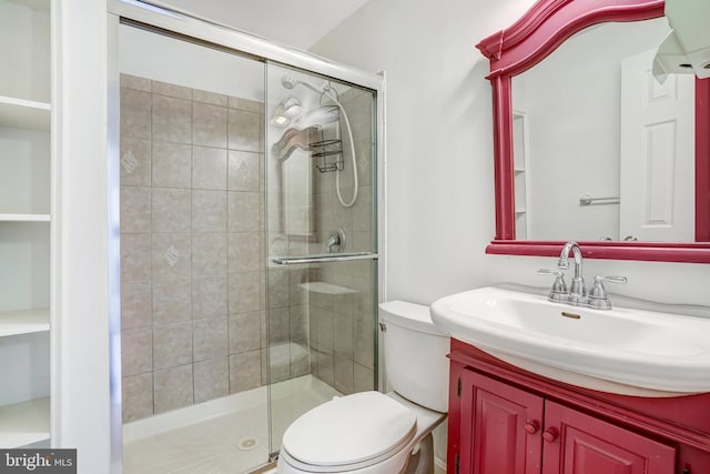 bathroom with vanity, toilet, and a shower with shower door