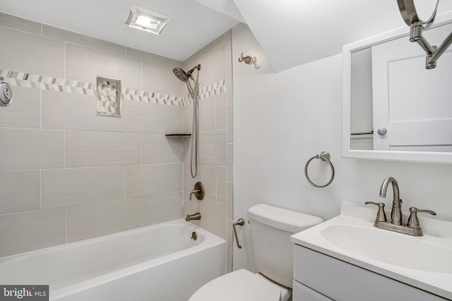 full bathroom with vanity, tiled shower / bath combo, and toilet