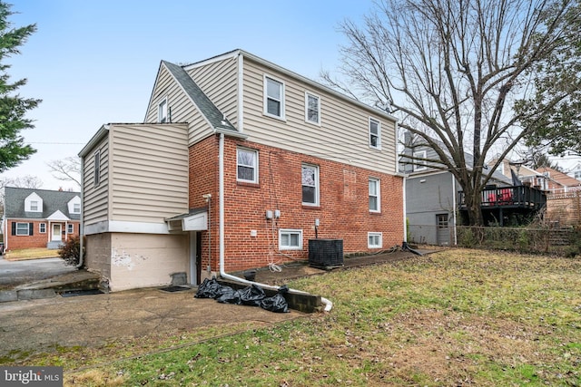 back of house featuring a garage, a yard, and central air condition unit