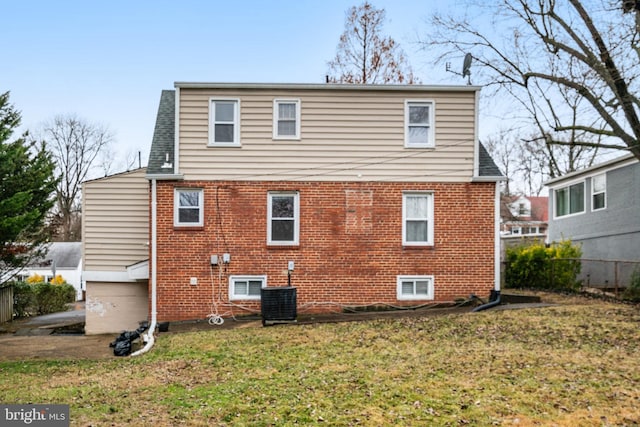 back of property with central AC and a lawn