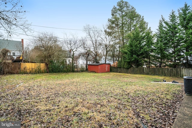 view of yard with central AC and a storage unit