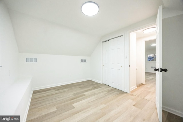 additional living space with lofted ceiling and light hardwood / wood-style floors