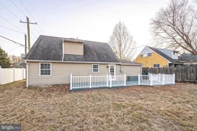 rear view of property featuring a wooden deck and a yard