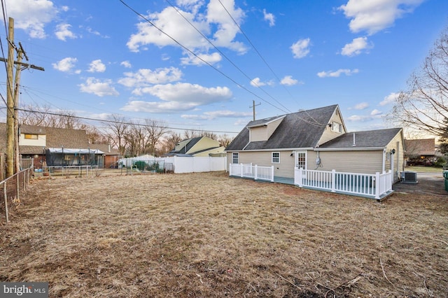 rear view of property with a lawn and central air condition unit