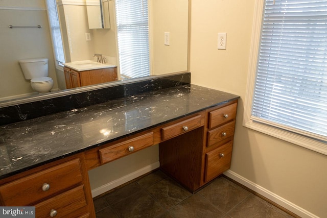 bathroom featuring vanity, toilet, tile patterned flooring, and a wealth of natural light