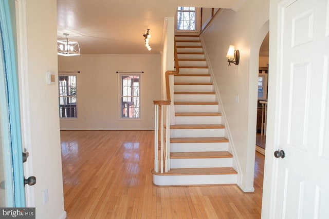 staircase with hardwood / wood-style flooring and ornamental molding