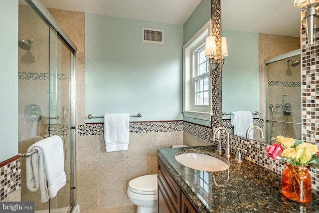 full bath with vanity, a shower stall, and visible vents