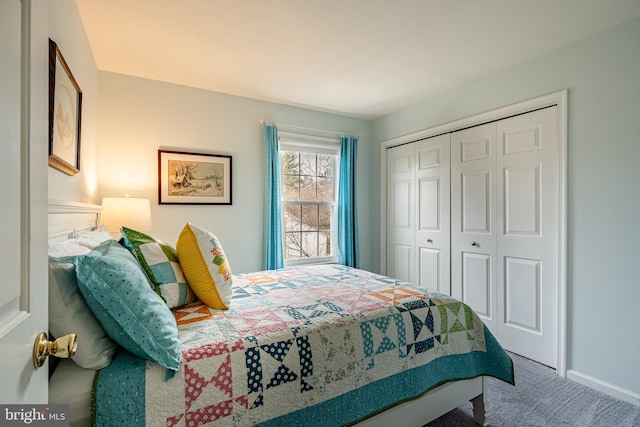 carpeted bedroom with a closet and baseboards