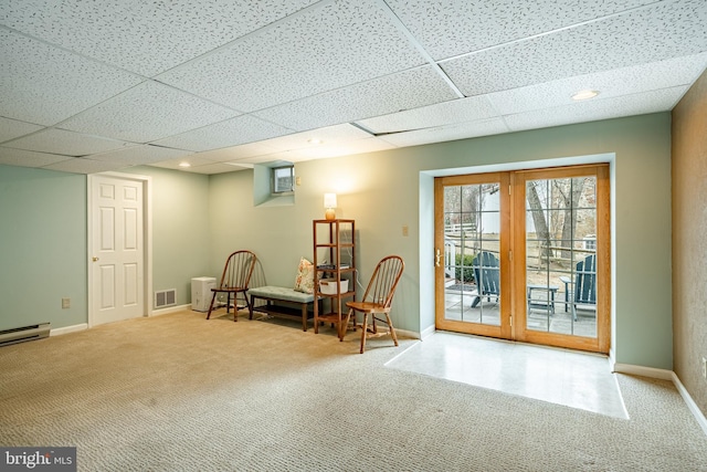 sitting room with carpet flooring, visible vents, baseboards, and a drop ceiling