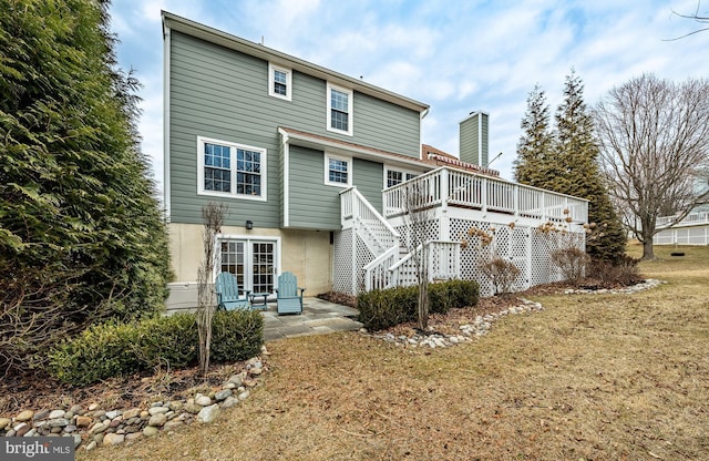 back of property with a yard, stairway, a patio, and a deck