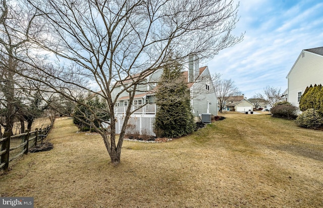 view of yard featuring central AC and fence