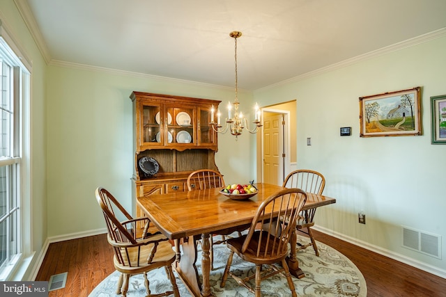 dining space with dark wood finished floors, crown molding, baseboards, and visible vents