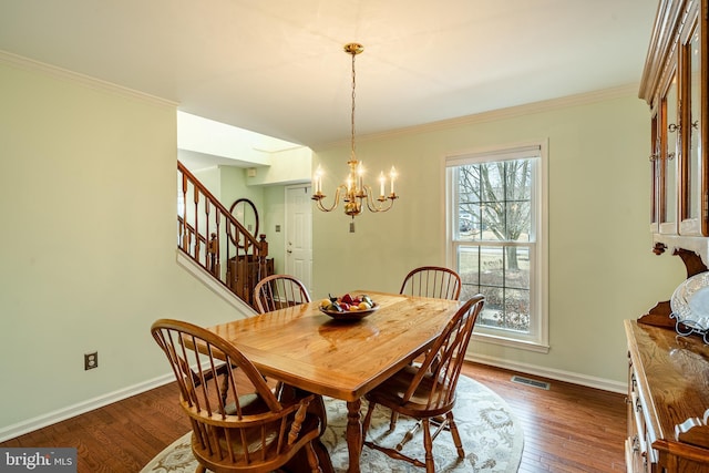 dining area with dark wood finished floors, baseboards, visible vents, and ornamental molding