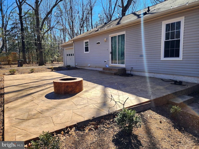 back of house featuring entry steps, a patio, a fire pit, and an attached garage