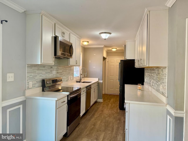 kitchen featuring light countertops, appliances with stainless steel finishes, a sink, and white cabinets