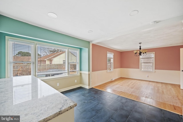 interior space with plenty of natural light, dark hardwood / wood-style flooring, and a chandelier