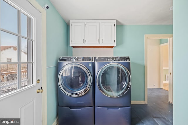 washroom featuring washer and dryer, cabinets, and dark tile patterned floors