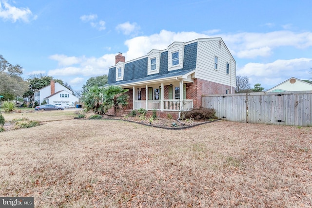 cape cod home featuring a porch and a front lawn