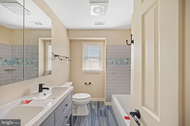 bathroom with hardwood / wood-style flooring, vanity, tiled shower, and toilet