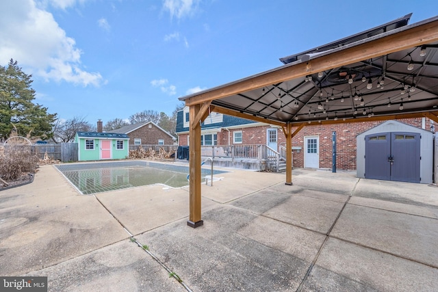 view of pool with a gazebo, a storage shed, and a patio area