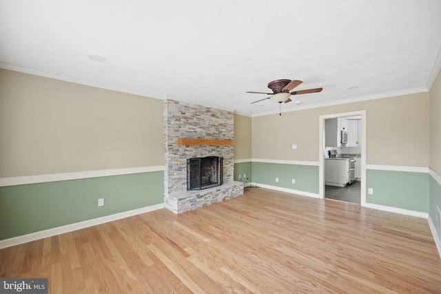 unfurnished living room with crown molding, ceiling fan, a fireplace, and hardwood / wood-style floors