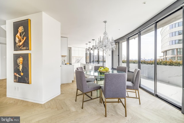 dining area featuring light parquet flooring, floor to ceiling windows, and an inviting chandelier