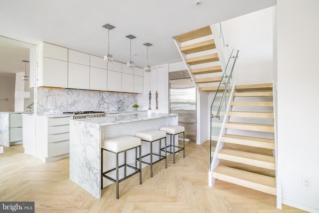 kitchen featuring built in refrigerator, white cabinetry, and a center island