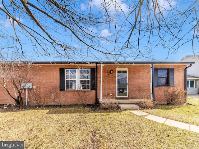 ranch-style home featuring a front yard and brick siding