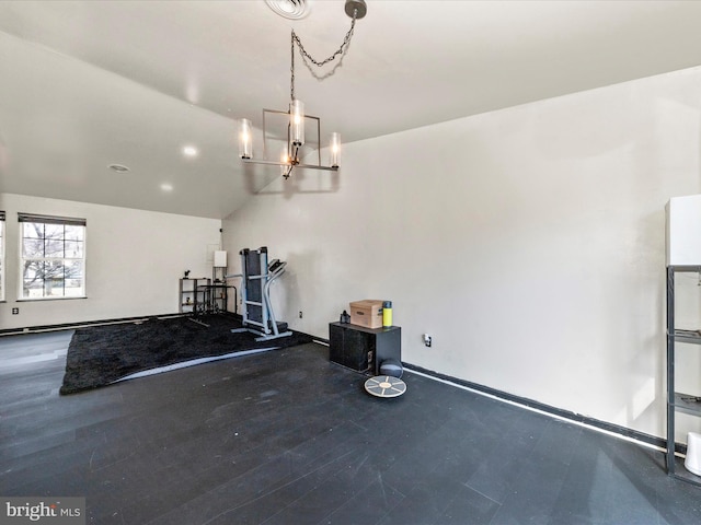 workout room with baseboards, a notable chandelier, and wood finished floors