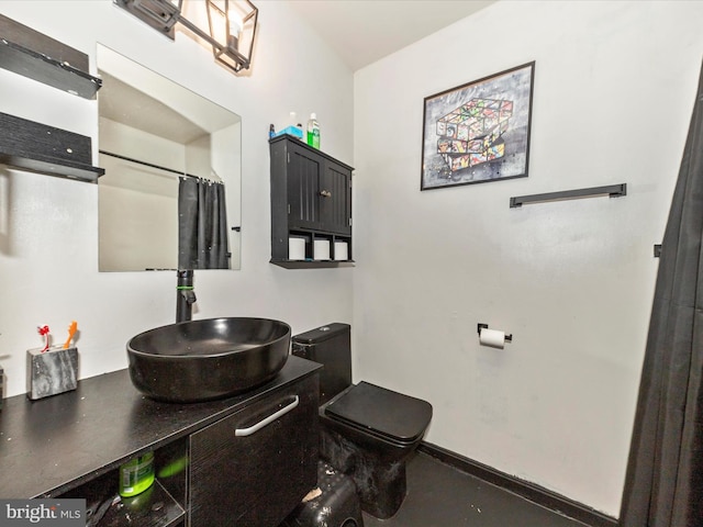 full bathroom with baseboards, vanity, and toilet