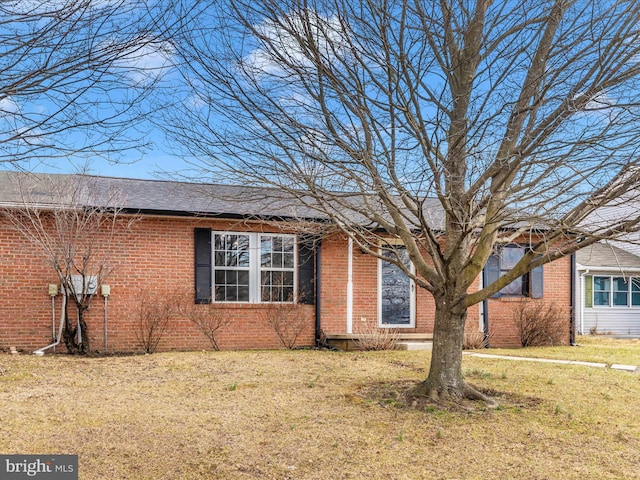 view of front of home with brick siding and a front yard