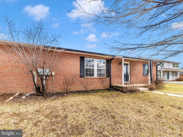 view of front facade featuring brick siding and a front yard