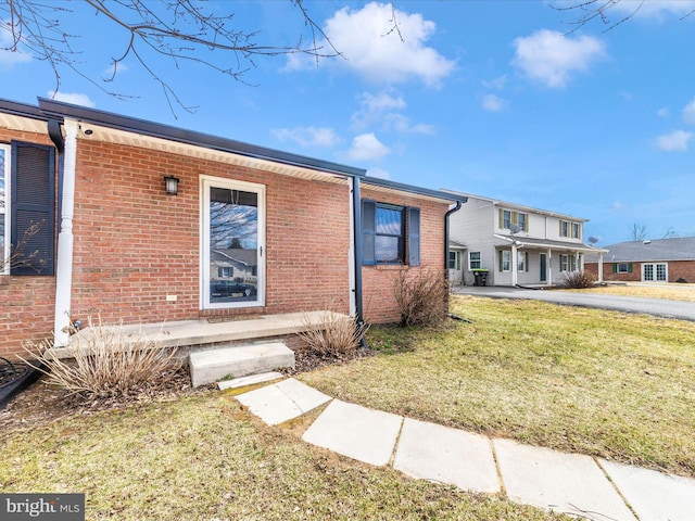 view of front of house featuring a front yard and brick siding